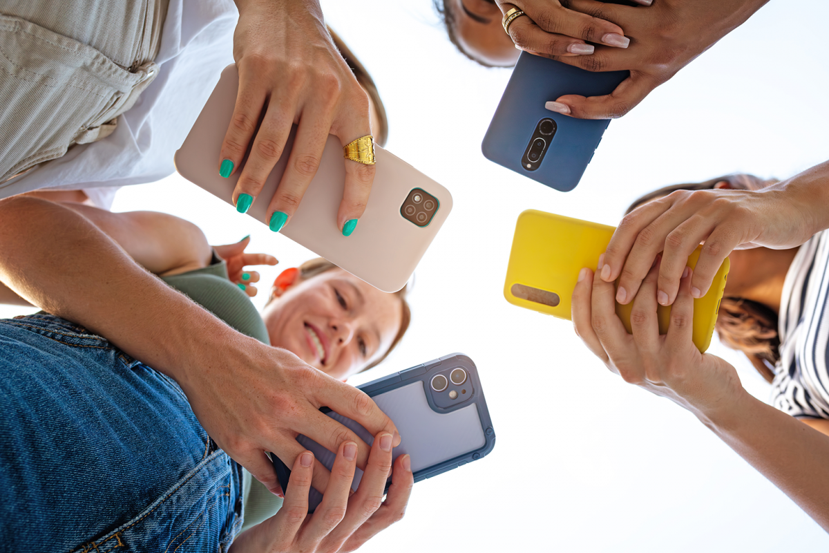low-angle-view-of-four-female-friends-using-phone-2026-03-17-06-32-56-utc